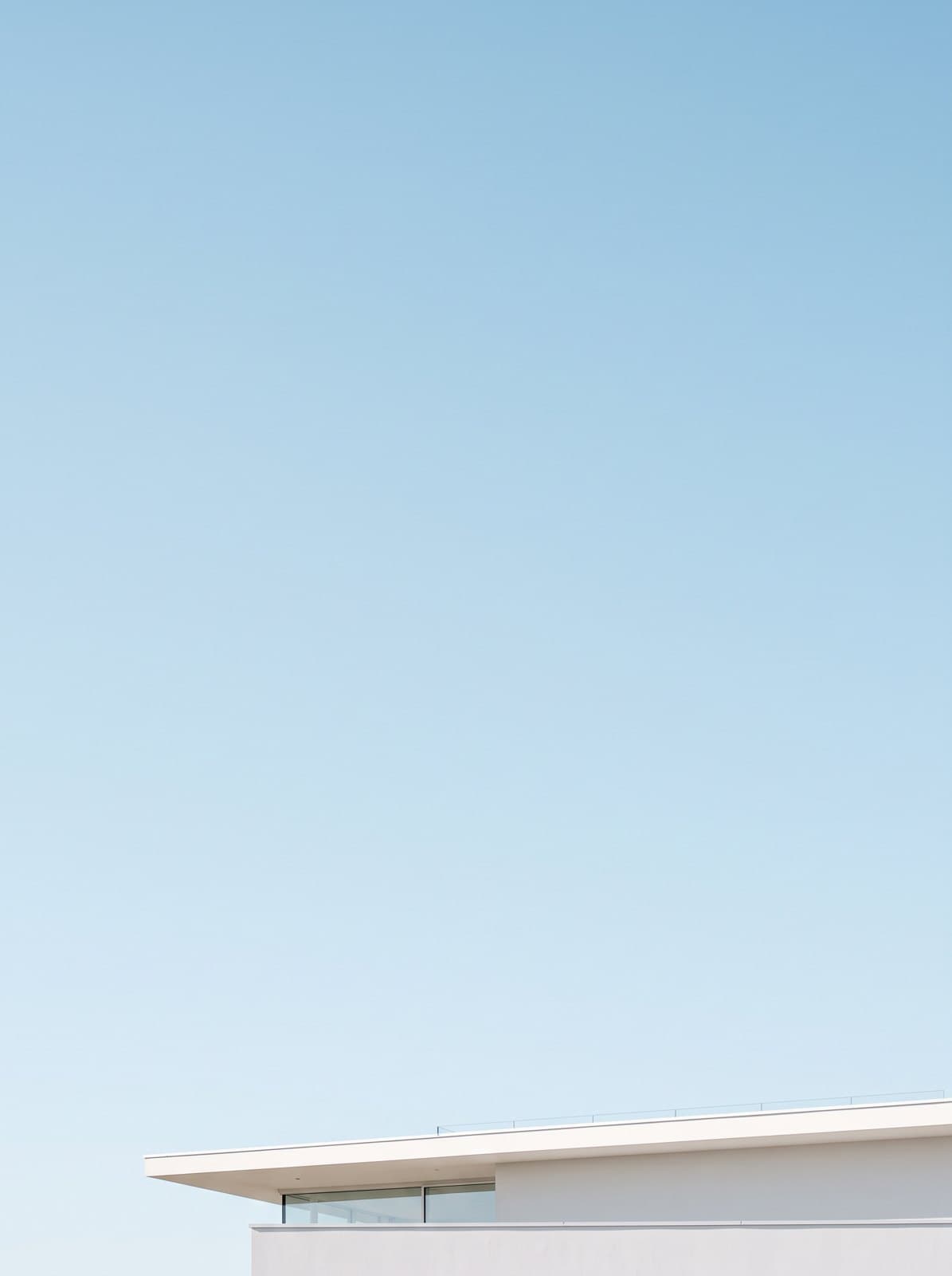 A white modern house against a bright pale sky