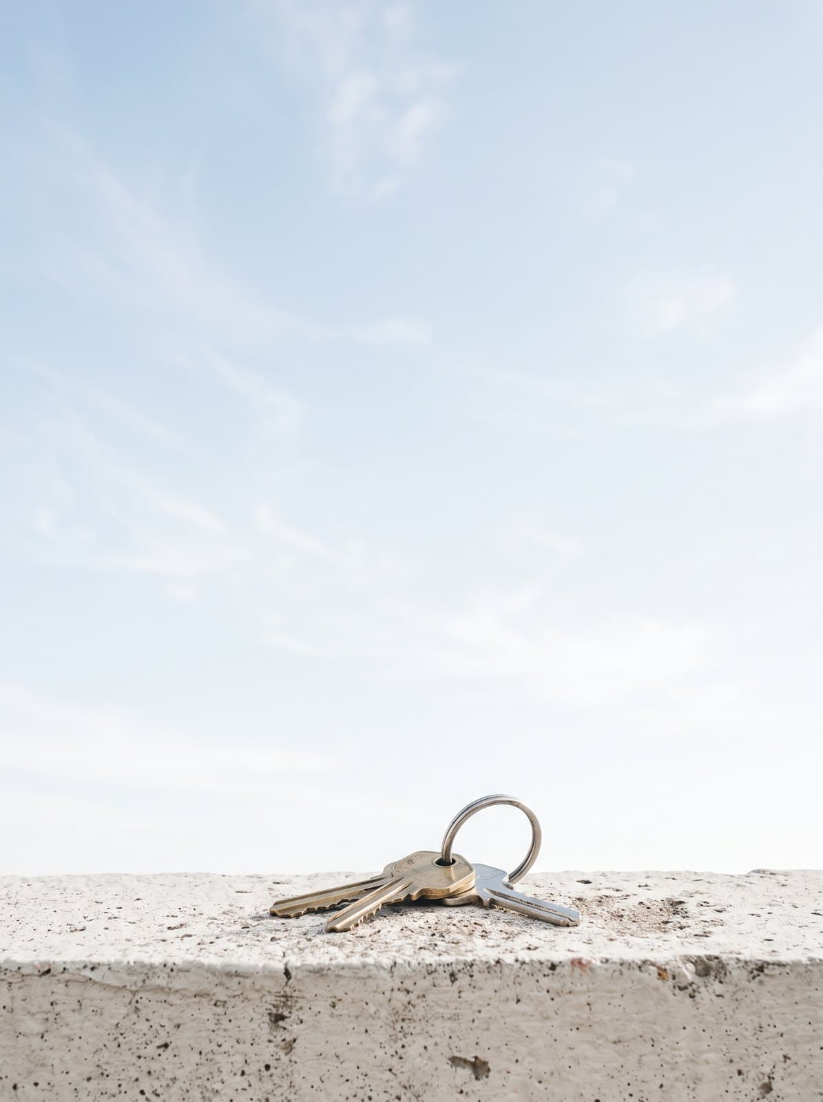 House keys on a ledge against the sky